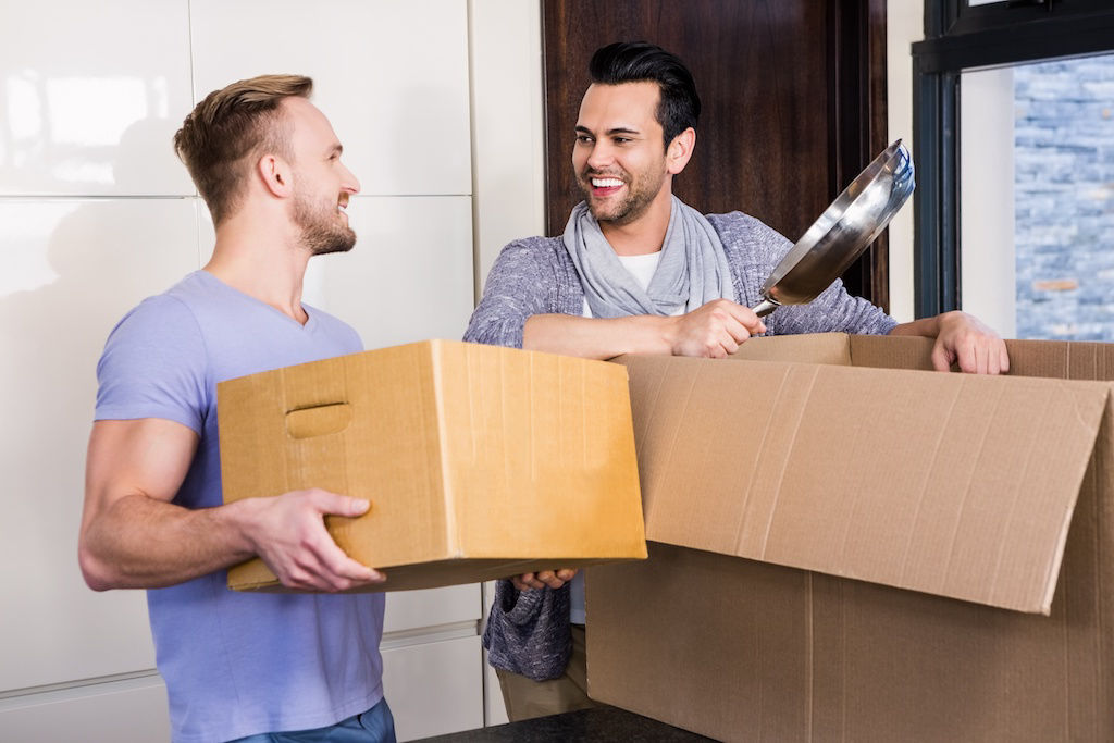 Male couple packing boxes to move